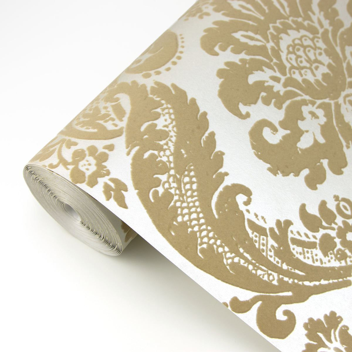 A close-up of York Wallcoverings’ Shadow Flocked Damask Wallpaper, featuring an ornate beige and white floral damask pattern on a white background.