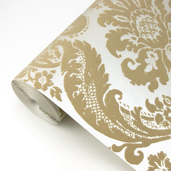 A close-up of York Wallcoverings’ Shadow Flocked Damask Wallpaper, featuring an ornate beige and white floral damask pattern on a white background.