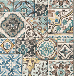 Featuring intricate geometric and floral patterns in vintage Mediterranean style, the Estrada Marrakesh Tiles Wallpaper by York Wallcoverings showcases a collage of decorative ceramic tile designs in blue, gray, cream, and gold tones.