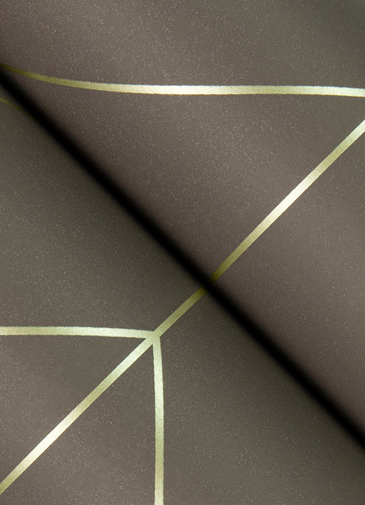 A close-up of the Sander Geometric Wallpaper by York Wallcoverings showcases metallic gold lines intersecting across a matte brown surface, forming striking angular shapes and modern abstract patterns.