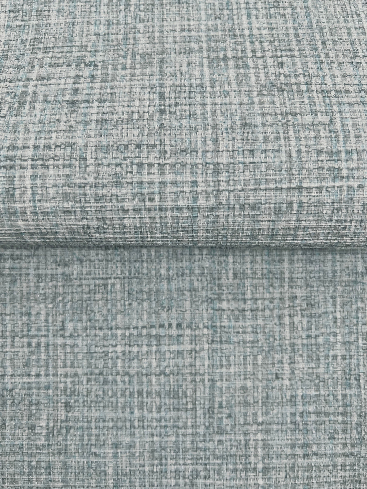 Clarkson Woven Wallpaper featuring a textured, woven pattern in shades of blue, gray, and white.