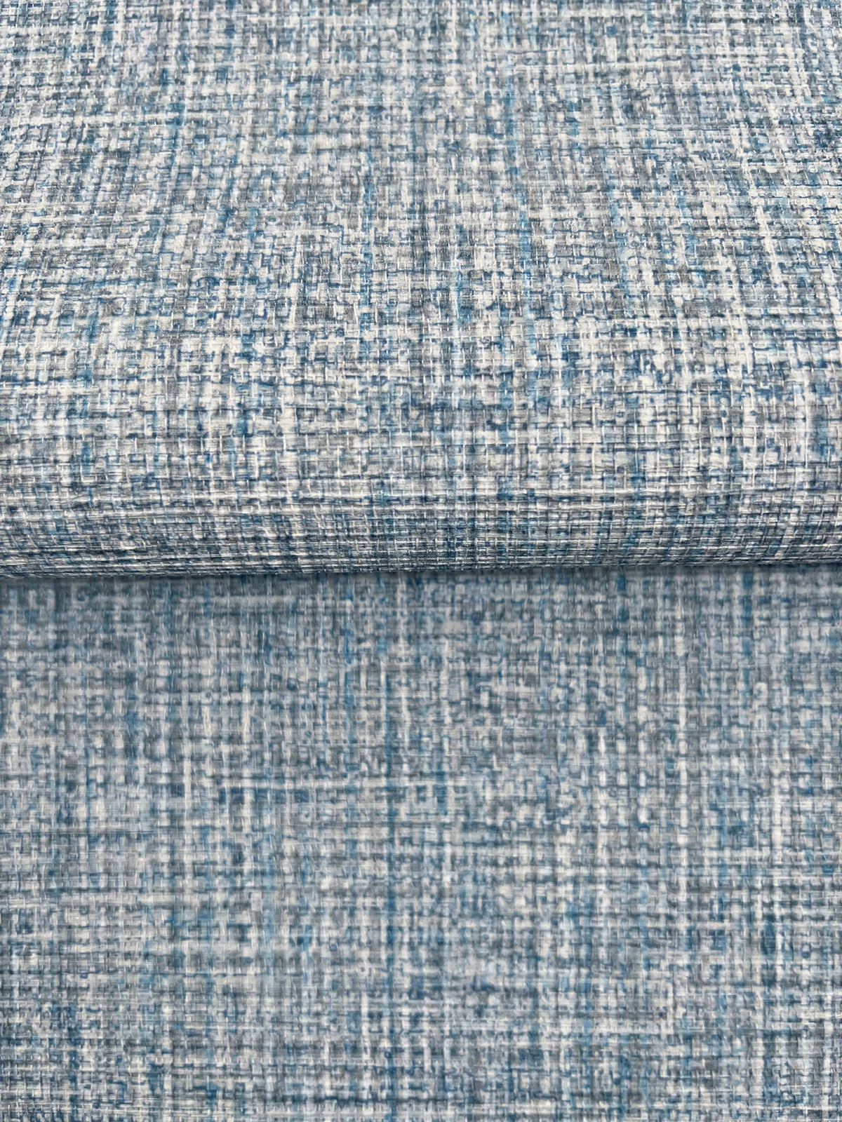 Clarkson Woven Wallpaper featuring a textured, cross-hatched pattern in shades of blue, grey, and white.