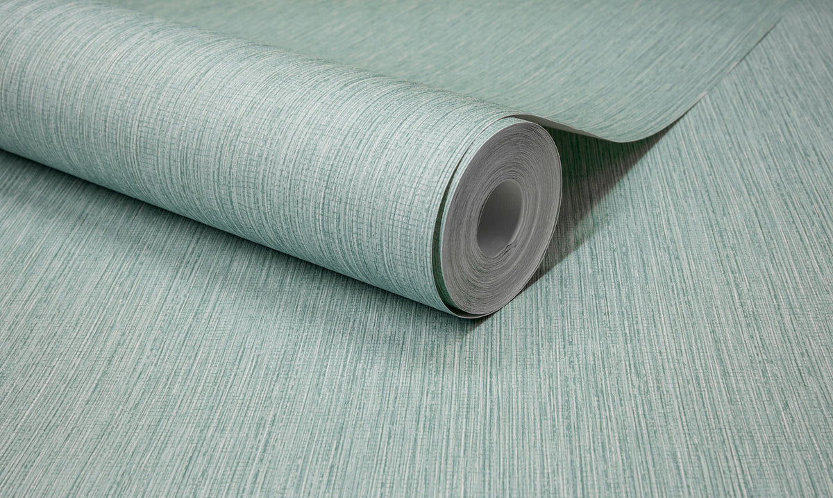 A close-up of a roll of York Wallcoverings Chesapeake Elijah Texture Wallpaper in light green, featuring subtle horizontal lines and a textured finish, partially unrolled on a flat surface.