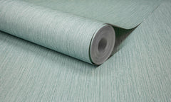 A close-up of a roll of Chesapeake Elijah Texture Wallpaper by York Wallcoverings, partially unrolled on a flat surface, showcases its light green hue and subtle vertical texture.