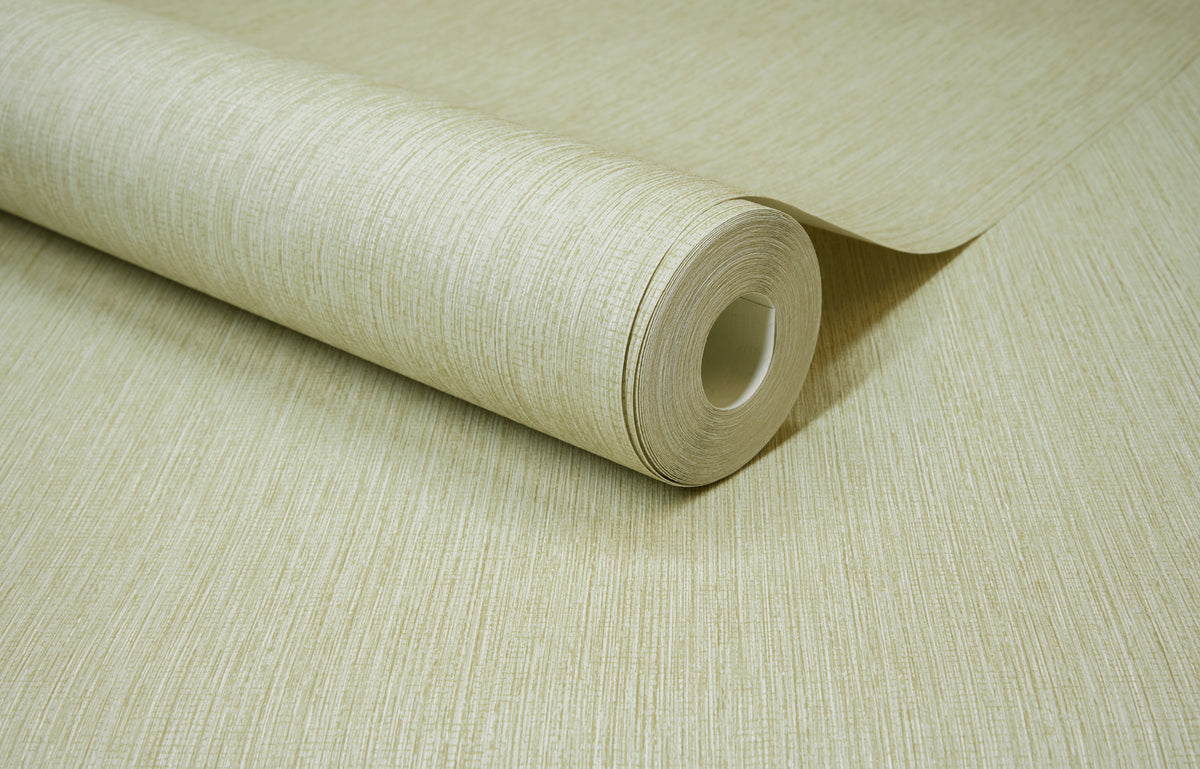 A close-up of a roll of Chesapeake Elijah Texture Wallpaper by York Wallcoverings, light beige and textured, partially unrolled on a matching surface.