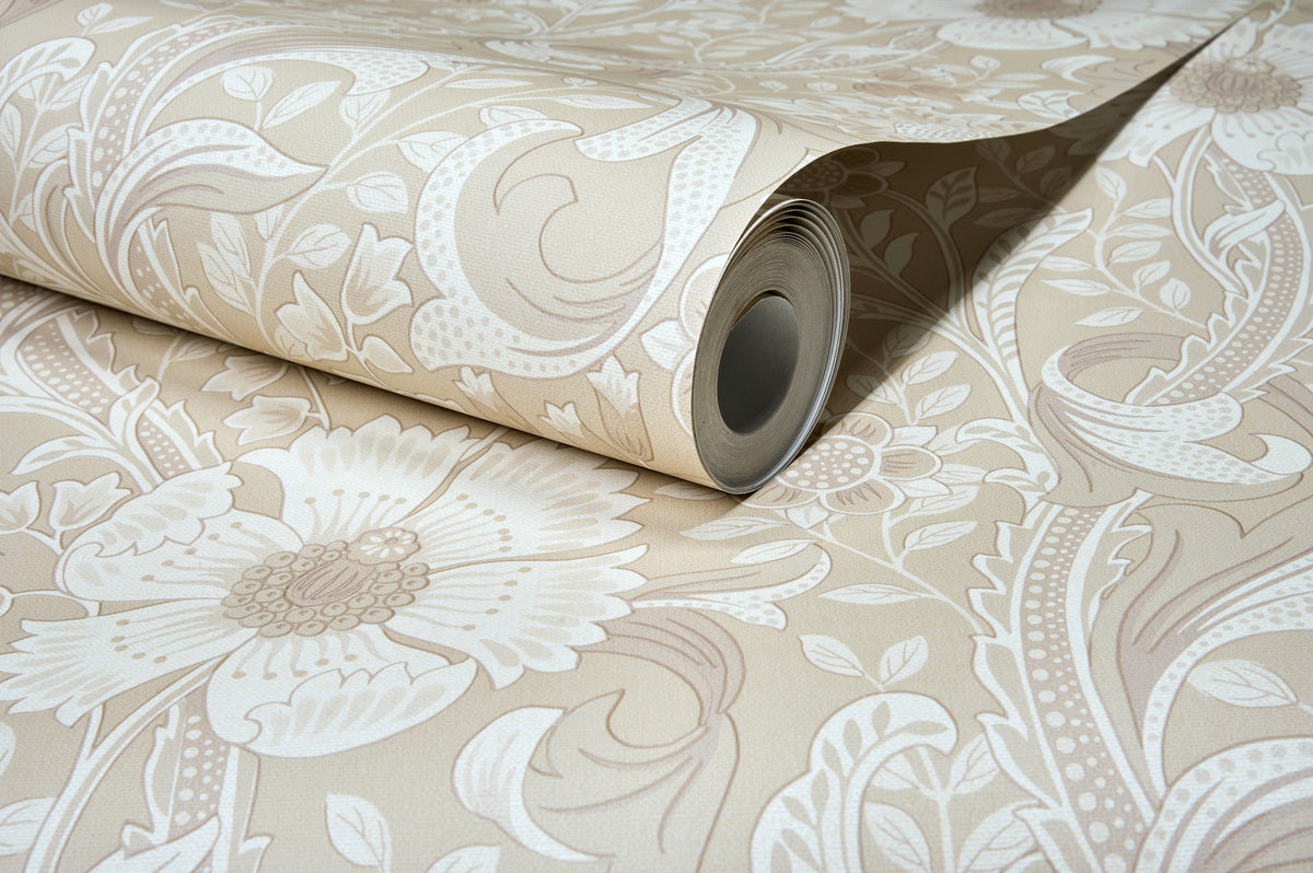 A partially unrolled roll of Chesapeake Liora Floral Trail Wallpaper by York Wallcoverings, showcasing its beige background adorned with large floral and leaf patterns on a flat surface.