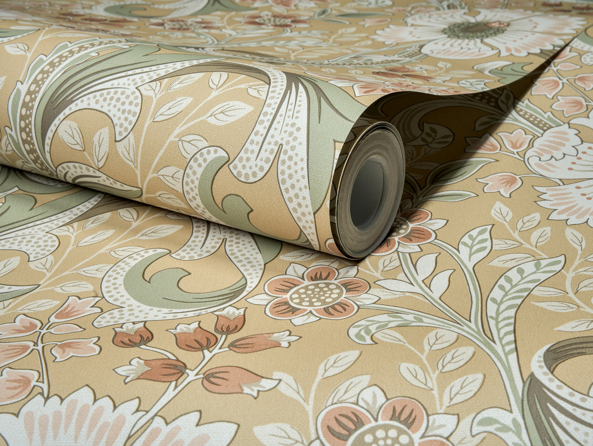 A close-up of the Chesapeake Liora Floral Trail Wallpaper by York Wallcoverings shows an unfolded section with a detailed floral pattern in beige, green, and muted red tones, featuring intricately designed leaves and flowers.