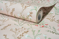 The York Wallcoverings Chesapeake Laverne Wildflowers Wallpaper, featuring a floral pattern in soft green, brown, white, and pink hues, is shown partially unrolled on a flat surface.