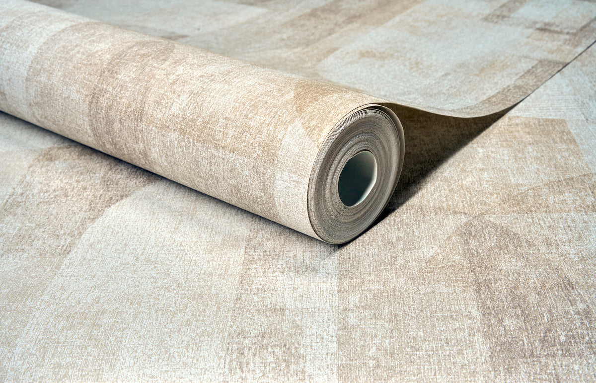 A close-up of a partially unrolled Chesapeake Cassandra Block Geometric Wallpaper roll by York Wallcoverings lying on a flat surface, showcasing its textured pattern and cylindrical shape.