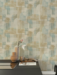 A minimalist room featuring the Chesapeake Cassandra Block Geometric Wallpaper by York Wallcoverings in beige and blue, complemented by a black table adorned with beige vases holding a single magnolia branch, a newspaper, and a softly draped beige cloth.