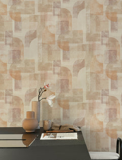 A modern dining table with tan vases, a flower branch, and a newspaper sits against a wall adorned with York Wallcoverings’ Chesapeake Cassandra Block Geometric Wallpaper.