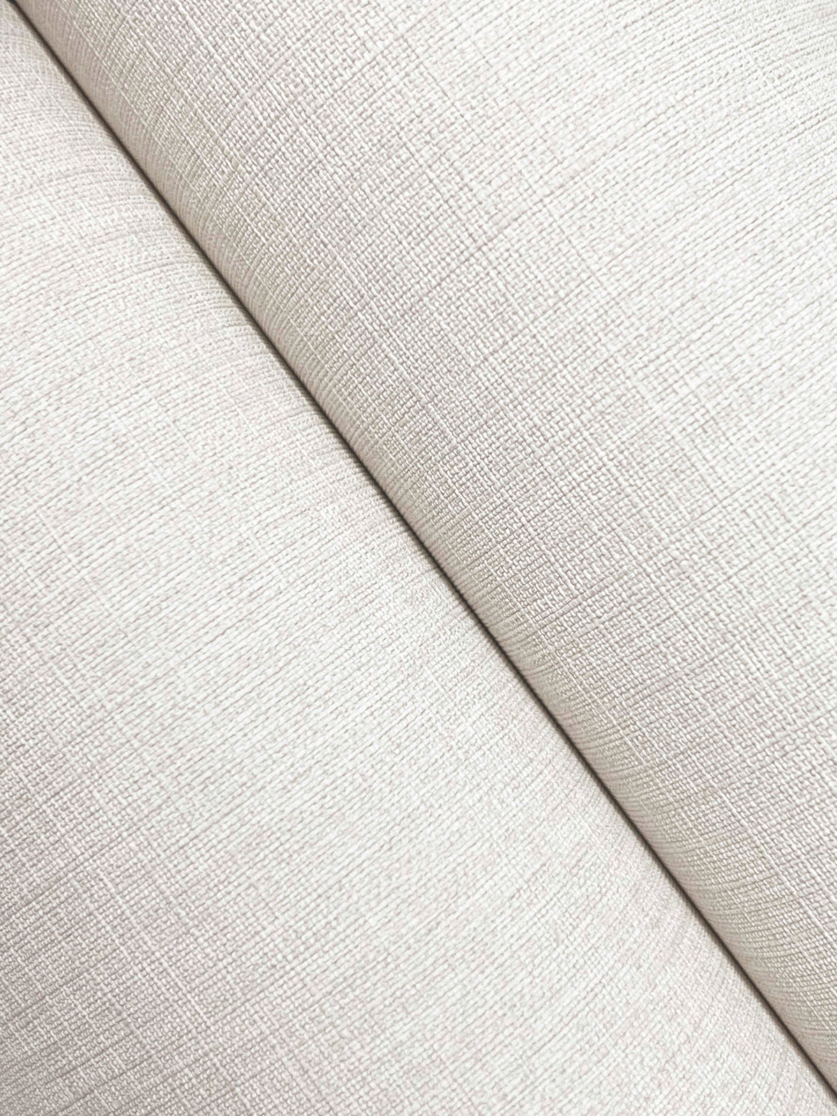 Close-up of two panels of Chesapeake Sonia Faux Linen Wallpaper by York Wallcoverings meeting at an angle, highlighting the off-white crosshatch texture and a subtle diagonal seam where the faux linen pattern intersects.