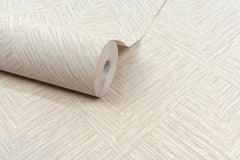 A close-up of the Chesapeake Hollis Textured Diamond Wallpaper by York Wallcoverings, featuring a partially unrolled beige roll that displays its subtle, textured diamond pattern across a flat surface.