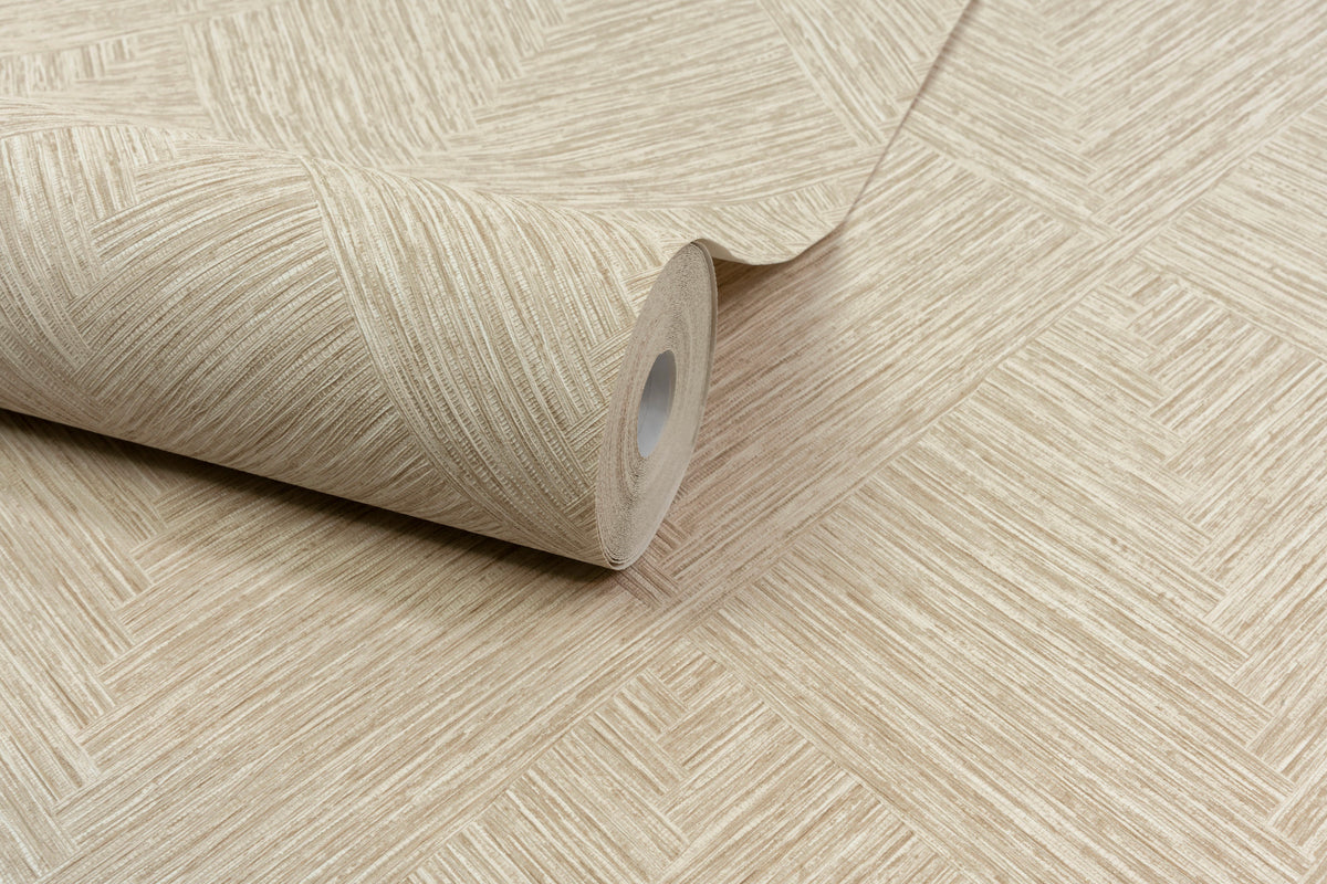 A roll of Chesapeake Hollis Textured Diamond Wallpaper by York Wallcoverings in beige, featuring a textured geometric pattern, is partially unrolled on a matching wallpapered surface.