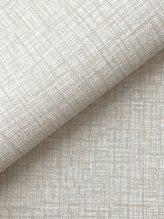 A close-up of York Wallcoverings’ Beau Faux Fabric Wallpaper, shown in beige with a subtle grid-like texture, partially folded over itself and casting a soft shadow across the lower half of the image.