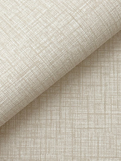 A close-up of Beau Faux Fabric Wallpaper by York Wallcoverings, featuring textured beige material with a subtle grid and crosshatch pattern, partially rolled atop a flat surface covered in the same wallpaper.