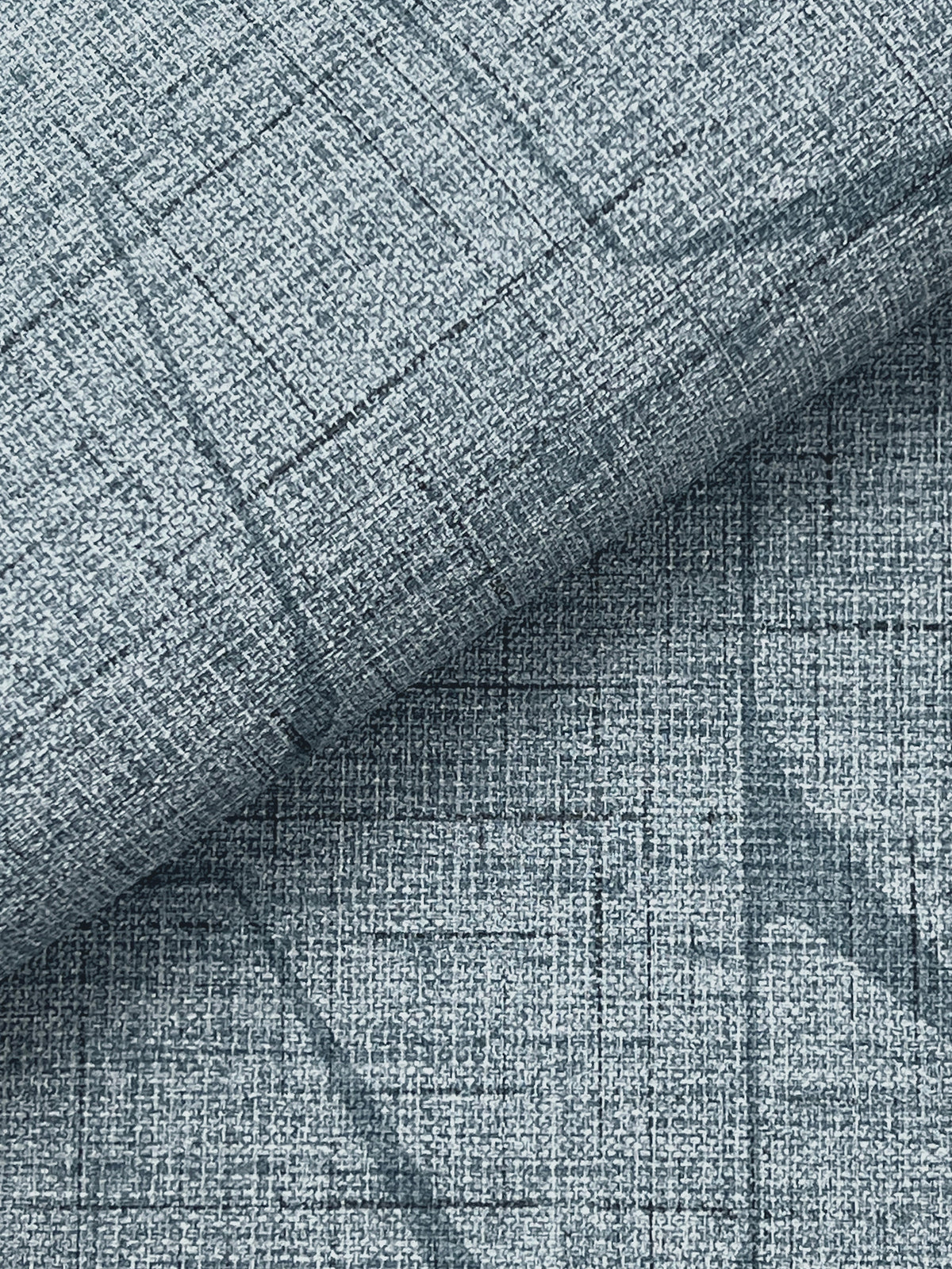 Close-up of Lyle Abstract Geometric Wallpaper by York Wallcoverings in light blue, featuring a textured surface with a subtle crisscross grid pattern and visible linear, woven details.