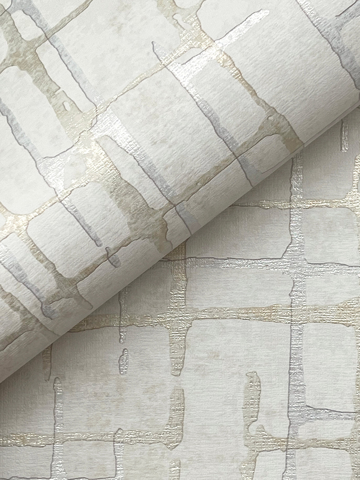 A close-up of the Rian Linear Abstract Wallpaper by York Wallcoverings, showcasing its textured surface with an abstract grid pattern in soft metallic and neutral tones, featuring overlapping lines and a subtle shine.