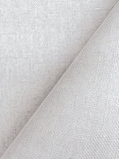 A close-up of York Wallcoverings’ Woven Linen Wallpaper in light gray, featuring a diagonal fold that highlights the intricate crisscross pattern and textured weave of the material.