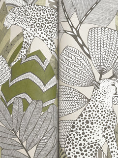 Namiri Wallpaper by York Wallcoverings features stylized black and white leopards with distinctive spots walking among large, patterned leaves and abstract green shapes in a nature-inspired design.