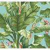 York Wallcoverings Banana Leaf Wallpaper features large tropical banana leaves in green and pink tones set against a light blue background, with small white flowers interspersed among the leaves.