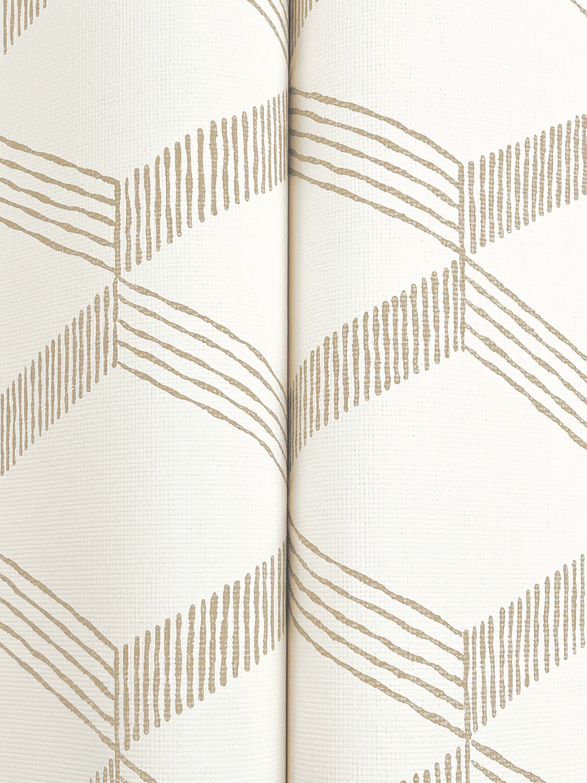 A close-up of the Palisades Paperweave Wallpaper by York Wallcoverings, featuring beige zigzag lines forming a geometric pattern on a white textured surface, with a vertical seam running down the center.