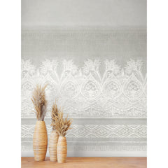 Three tall vases with dried grasses stand on a wooden floor in front of a light gray wall adorned with the Henna Wall Mural by York Wallcoverings, featuring an intricate white floral and geometric pattern.