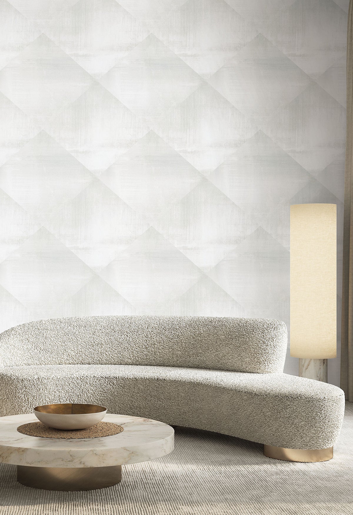 In Clay Wallpaper by York Wallcoverings in a light gray repeating diamond pattern on a wall behind a curved sofa, a marble coffee table, and a tall floor lamp.