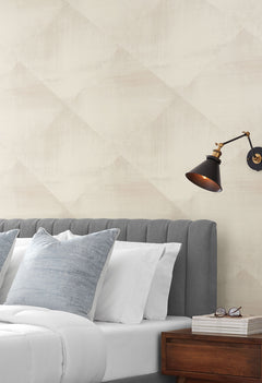 In Clay Wallpaper features a neutral-toned, subtle, large-scale diamond pattern behind a bedroom headboard.