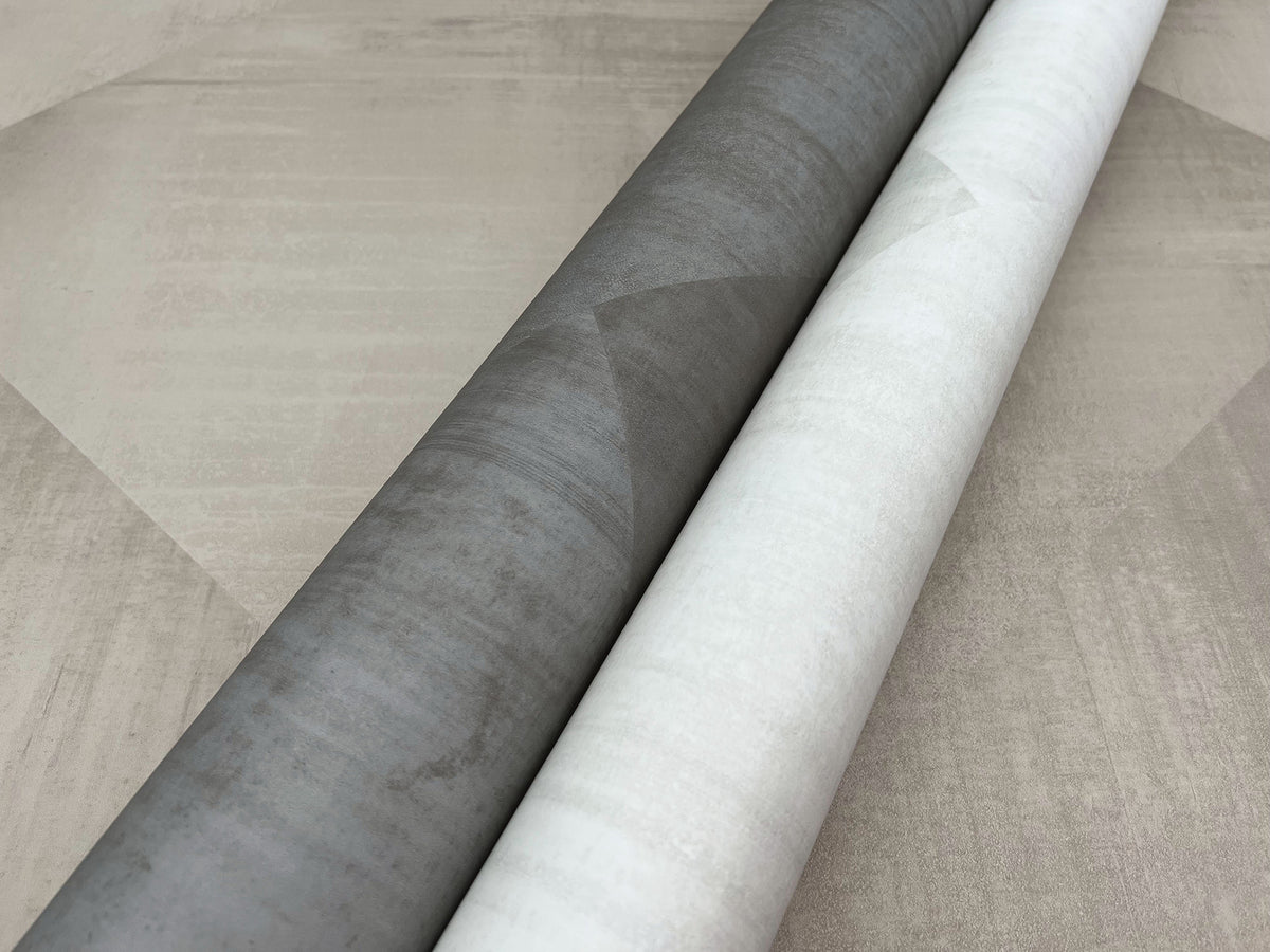 Two rolls of In Clay Wallpaper with a subtle geometric pattern, shown in dark gray and light gray side by side.