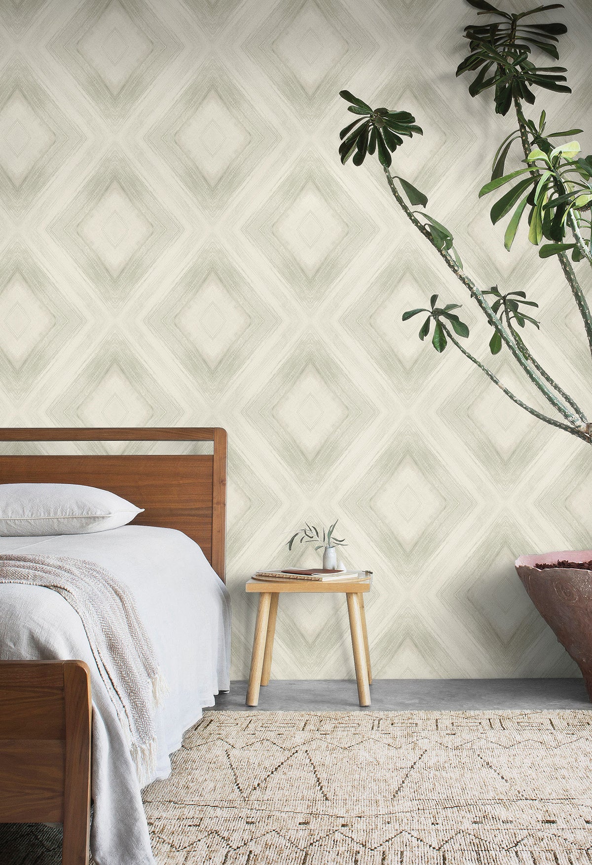 A bedroom wall featuring Ballad Wallpaper, which displays a large-scale, soft-edged diamond pattern in neutral tones.