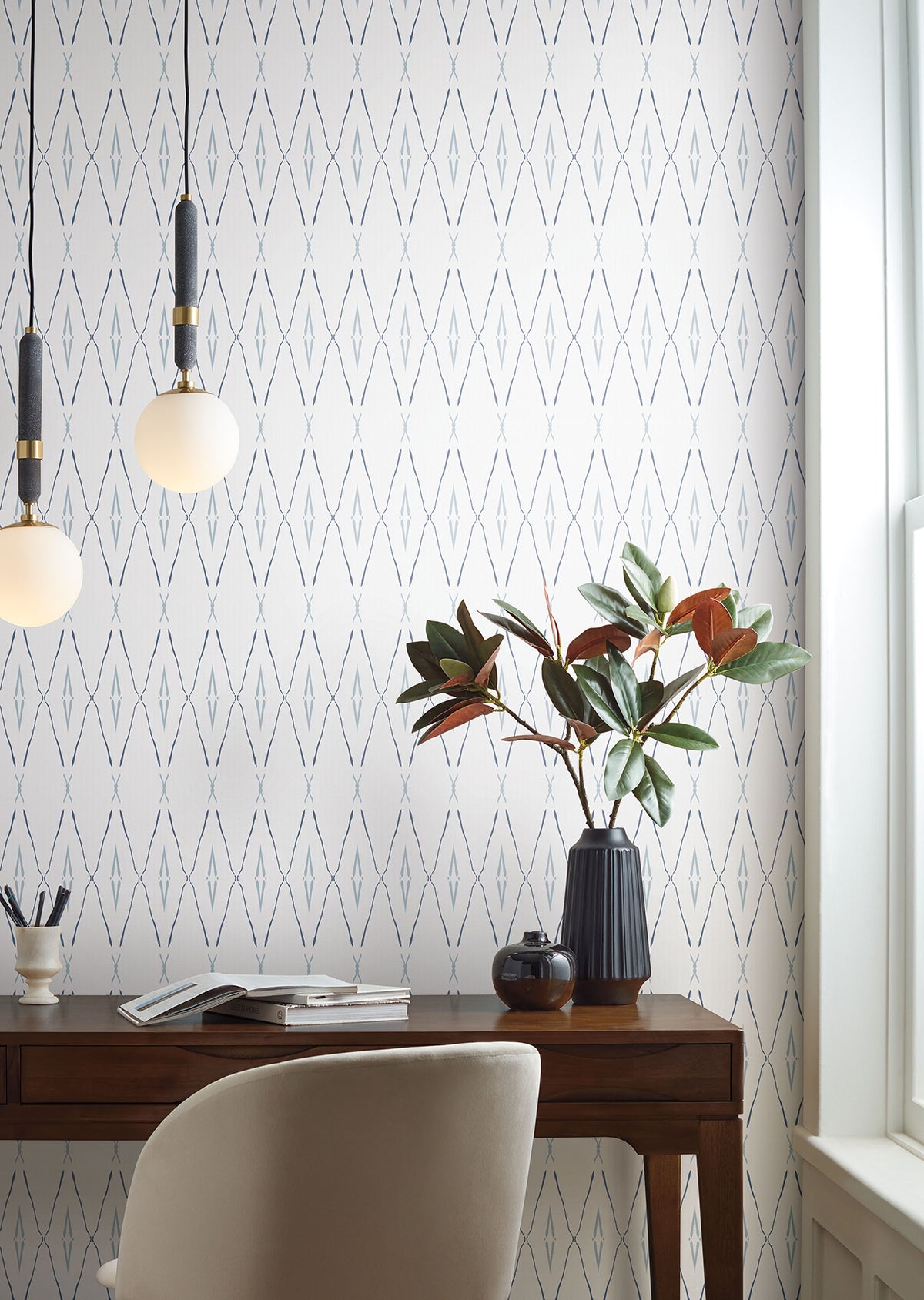 Artifact Silhouettes Wallpaper featuring a repeating pattern of thin, vertical blue and gray diamond shapes on a white background, installed in a home office with a wooden desk and chair.