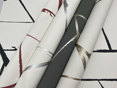 Four rolls of Intersect Wallpaper featuring abstract geometric lines and curved brushstrokes in black, red, silver, and gold.