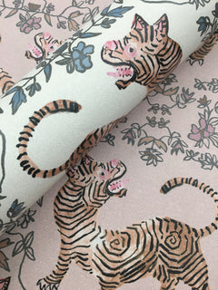 Ferrandi Wallpaper featuring a repeating pattern of tigers and floral vines in black, pink, and blue on a pale pink background.