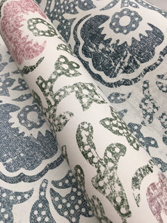 Blaise Wallpaper roll featuring a distressed floral and paisley pattern in shades of pink, green, and blue on a white background.