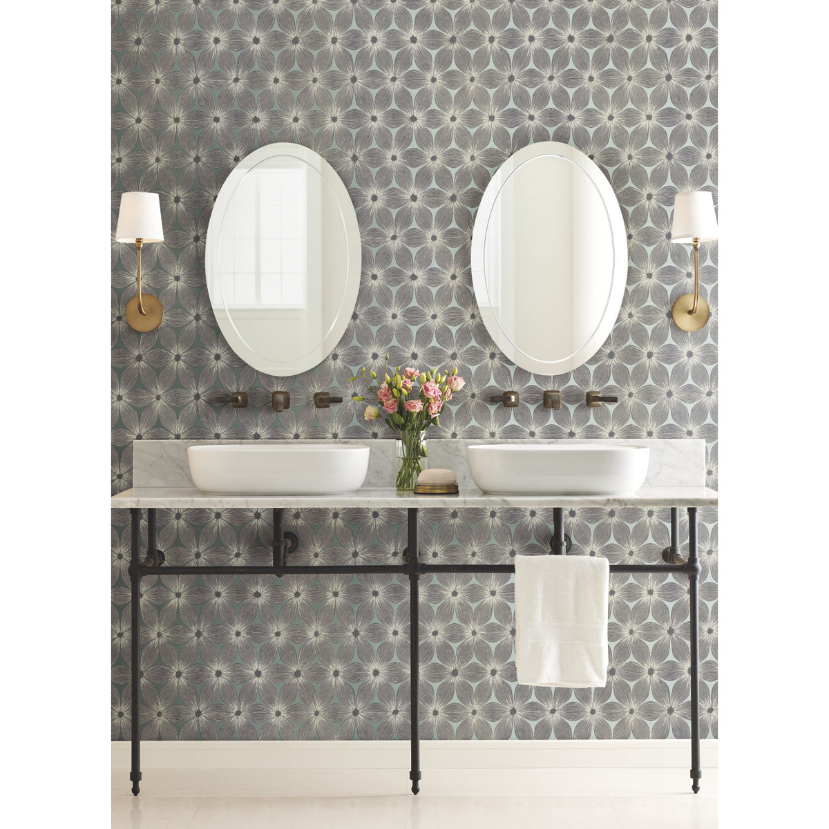 A bathroom vanity with two oval mirrors and vessel sinks set against Candice Olson Everlasting Wallpaper by York Wallcoverings.