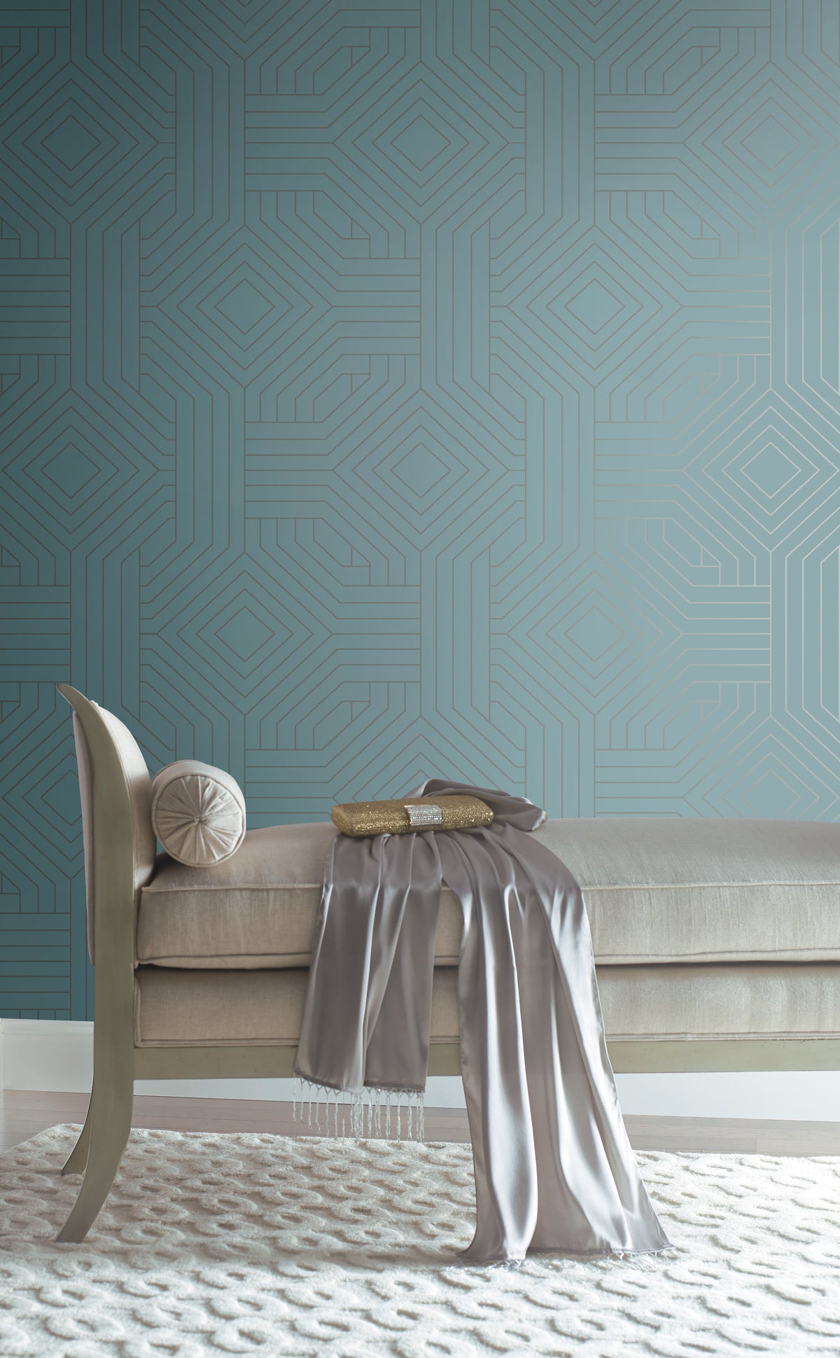 Candice Olson Diverging Diamonds Wallpaper in teal with a repeating gold geometric diamond pattern behind a neutral-toned chaise lounge.