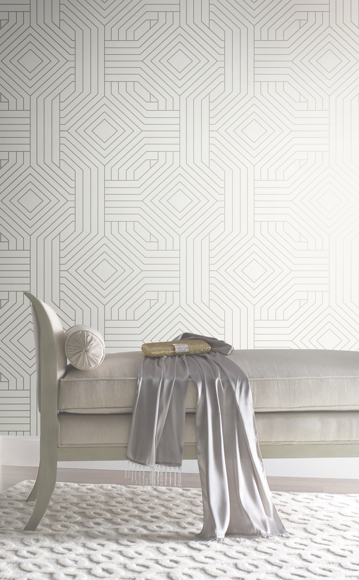 A tufted bench with a silk scarf and gold clutch sits against Candice Olson Diverging Diamonds Wallpaper by York Wallcoverings, featuring a geometric pattern of interlocking diamonds and lines.