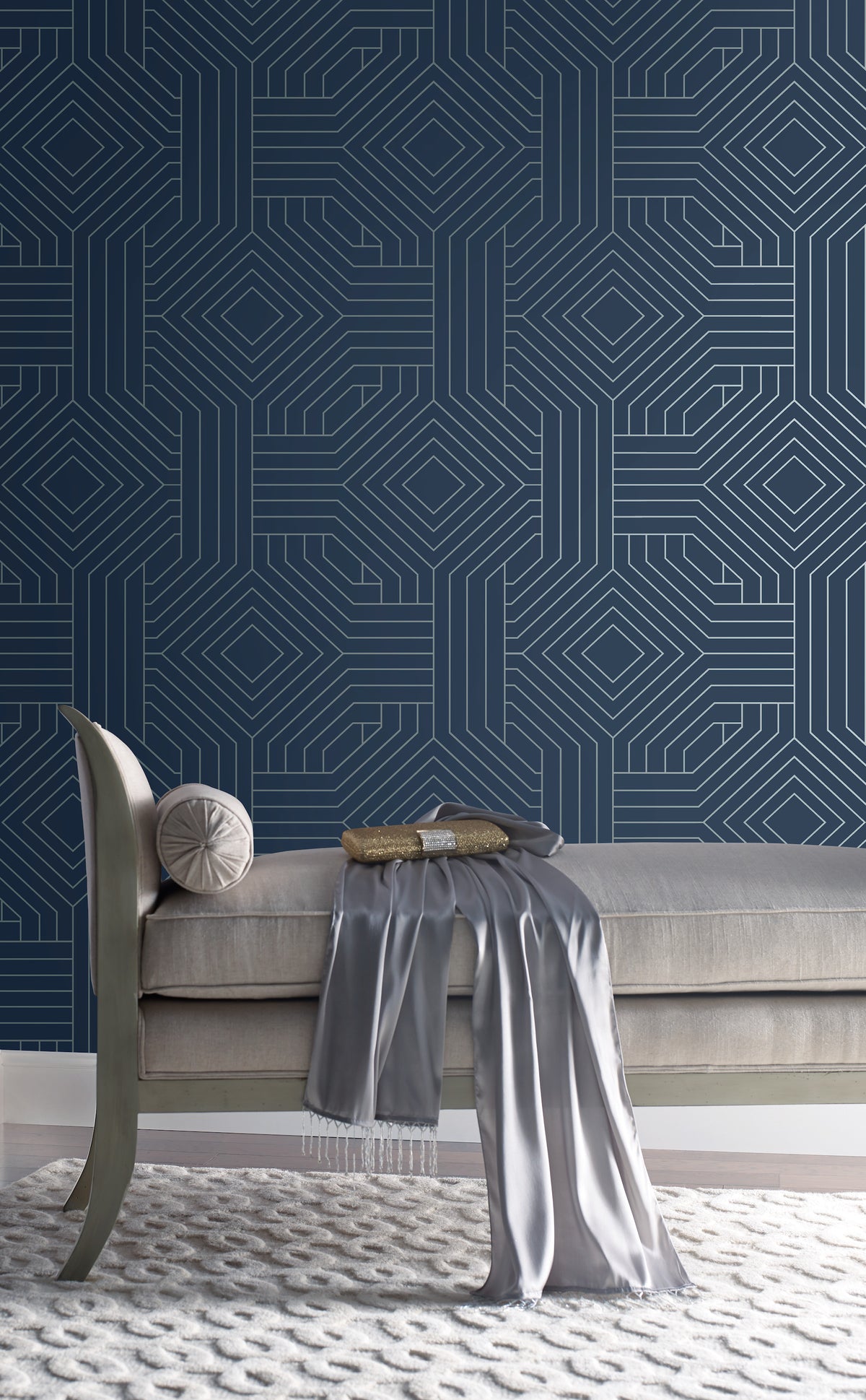 A bench sits in front of a wall covered in navy blue Candice Olson Diverging Diamonds Wallpaper by York Wallcoverings, featuring a white geometric pattern of interlocking diamonds.
