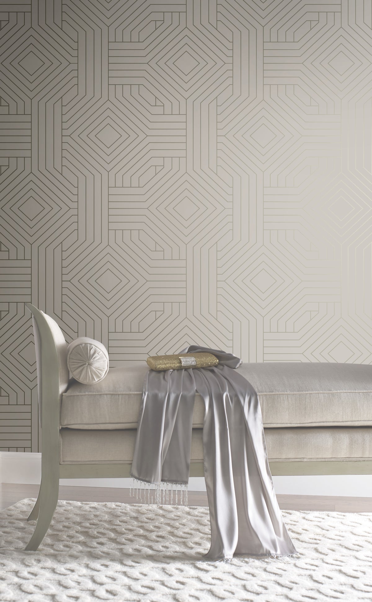 Candice Olson Diverging Diamonds Wallpaper by York Wallcoverings featuring a geometric pattern of gold lines forming interlocking diamonds against a neutral background, positioned behind a tufted bench.