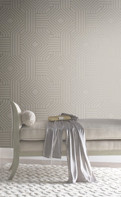 Candice Olson Diverging Diamonds Wallpaper by York Wallcoverings featuring a geometric pattern of gold lines forming interlocking diamonds against a neutral background, positioned behind a tufted bench.