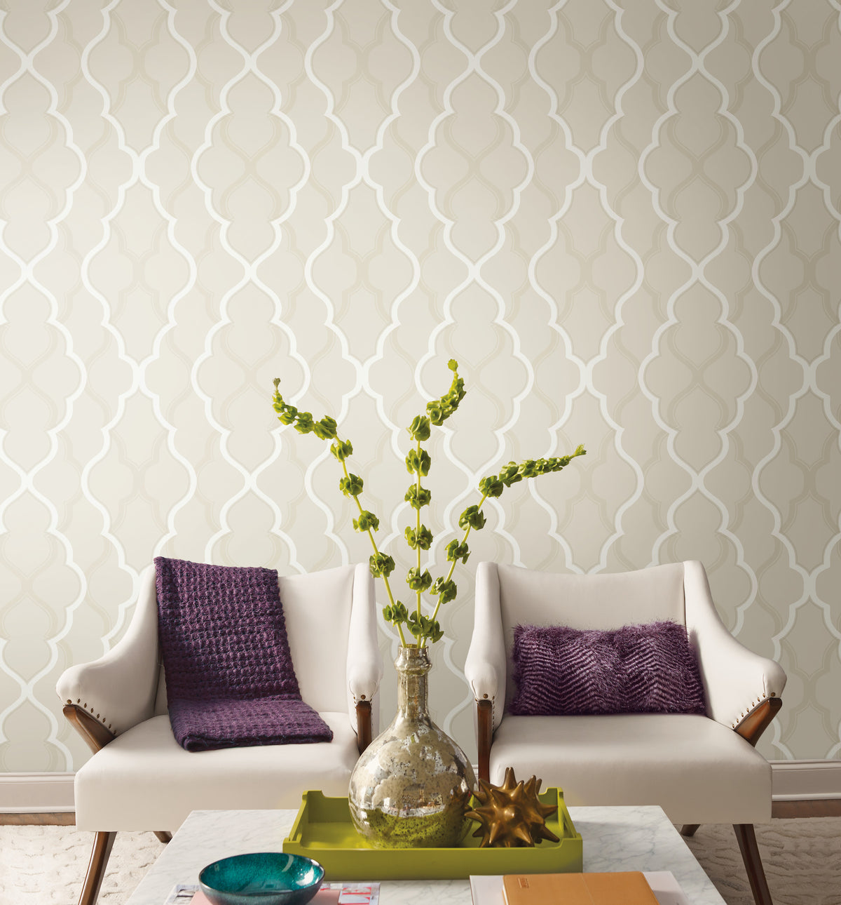 Two cream-colored armchairs with purple pillows set against a wall featuring York Wallcoverings Candice Olson Double Damask Wallpaper.