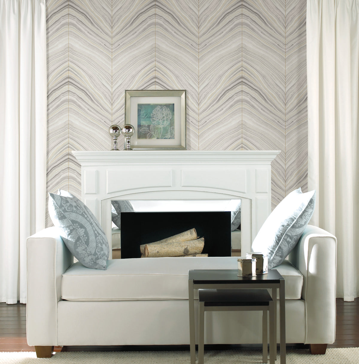 White sofa positioned in front of a fireplace with Candice Olson Onyx Strata Wallpaper by York Wallcoverings in the background.