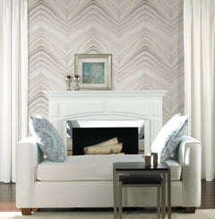 White sofa positioned in front of a fireplace with Candice Olson Onyx Strata Wallpaper by York Wallcoverings in the background.