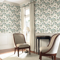 Two upholstered chairs set against a wall featuring Candice Olson Flourish Wallpaper with a repeating pattern of teal and grey stylized floral bursts.
