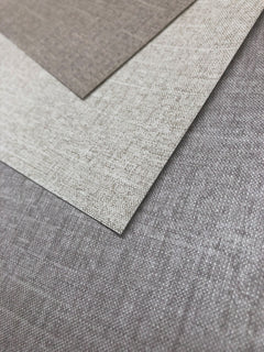 Three overlapping samples of Candice Olson Errandi Wallpaper by York Wallcoverings in shades of taupe, beige, and grey with a subtle woven texture.