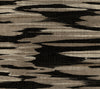 Nimbus Wallpaper by York Wallcoverings features an abstract pattern of irregular, horizontal stripes in black, brown, and beige tones, evoking the look of wood grain or camouflage with a textured, woven finish.