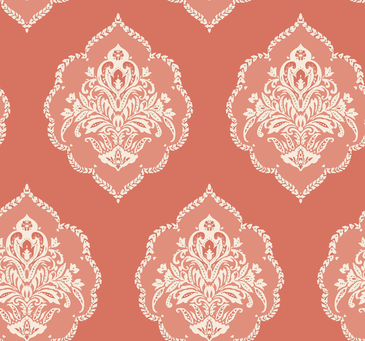 The Signet Medallion Damask Wallpaper by York Wallcoverings features an elegant, vintage-inspired design with ornate white floral motifs arranged in a seamless pattern over a muted coral background.