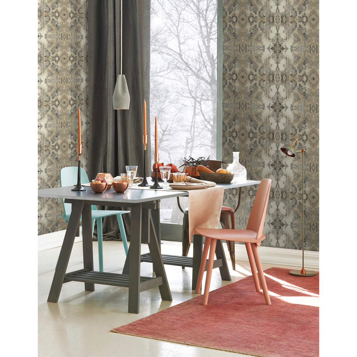 Dining room featuring Inner Beauty Wallpaper by York Wallcoverings, with a gray table set with bowls and candles, and chairs in teal, coral, and dark gray.