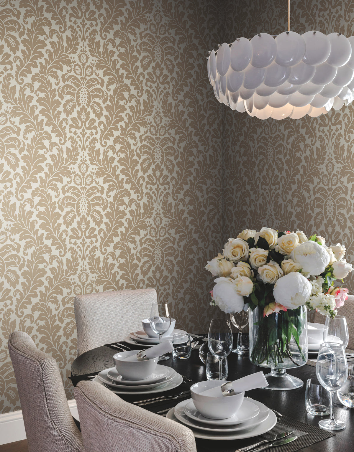 Dining room featuring Candice Olson Modern Romance Wallpaper by York Wallcoverings with tan and white scrolling foliage, seen behind a round table set for four with a large bouquet of roses.